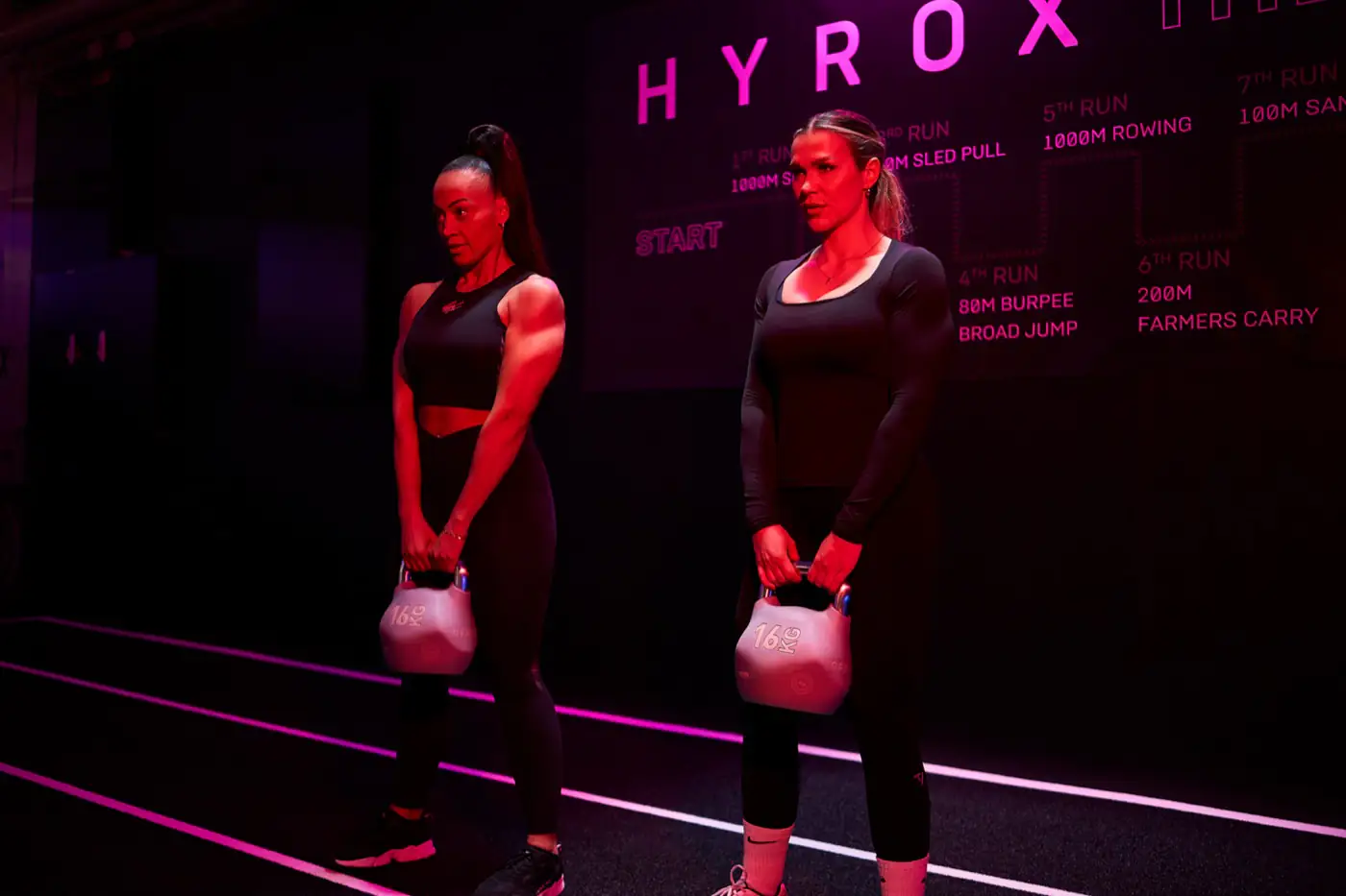 Farmers Carry vor dem HYROX Schriftzug beim Signature Kurs