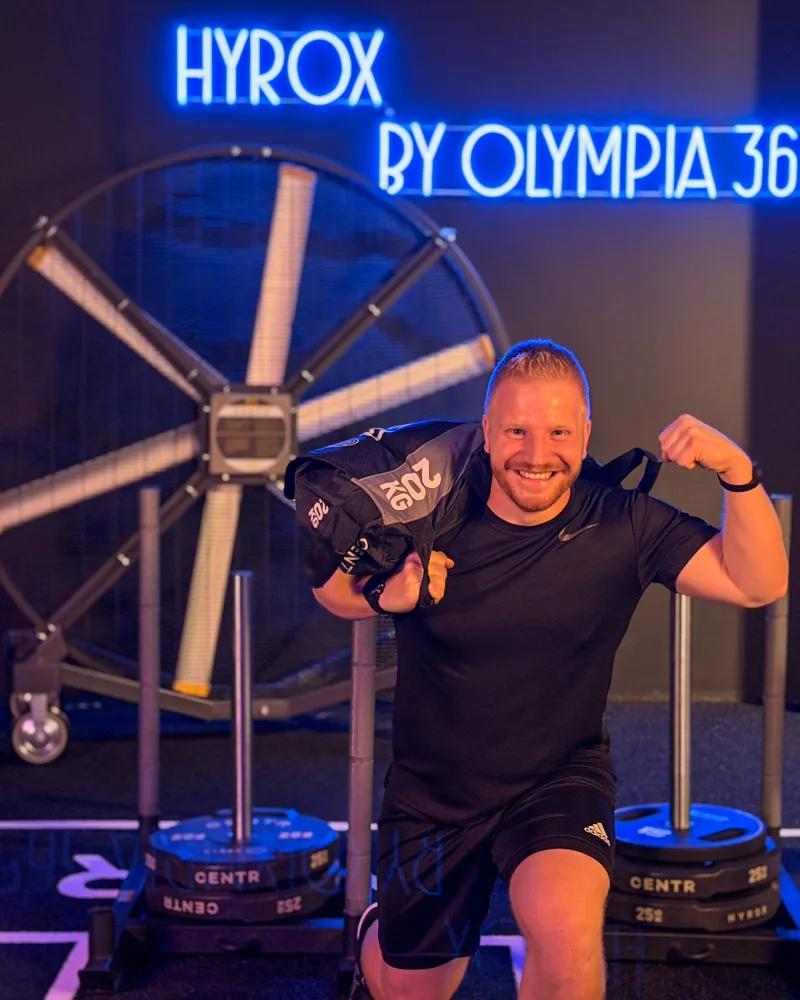 Felix mit Sandbag vor dem HYROX Neonschild bei OSF 365